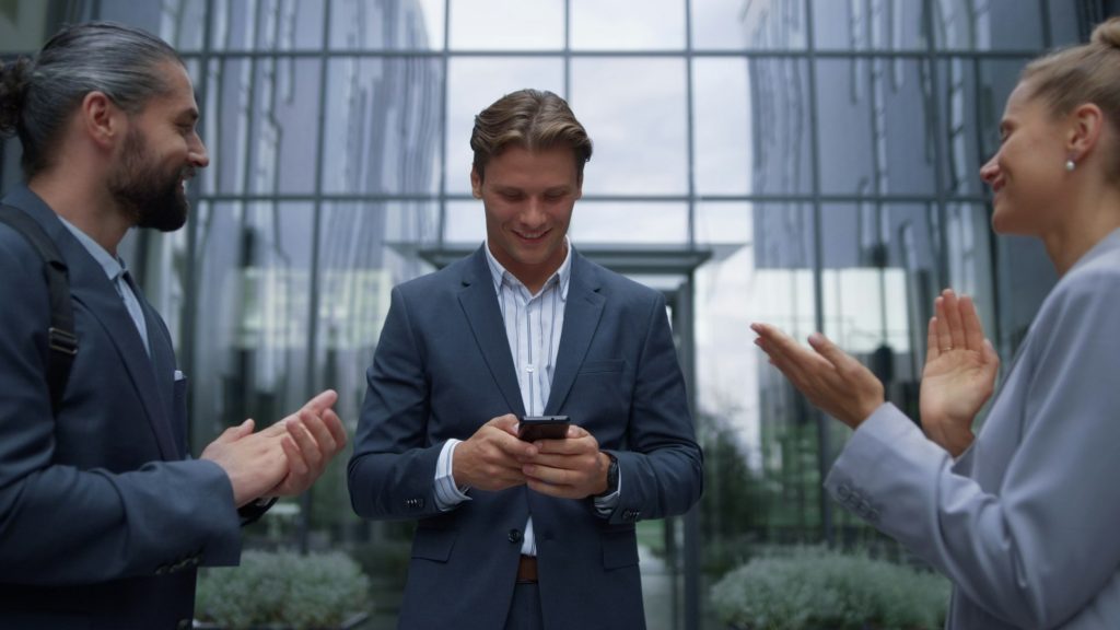 Businessman announce happy news to employees. Smiling staff applauding leader.