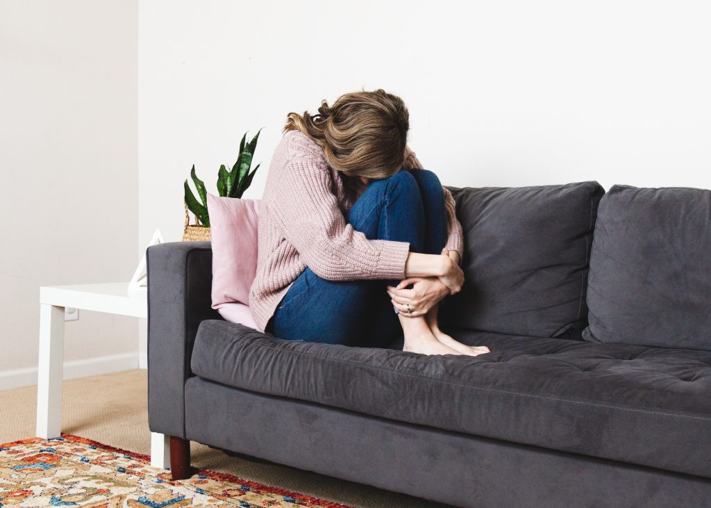 Woman sitting on the couch struggling with depression and mental health