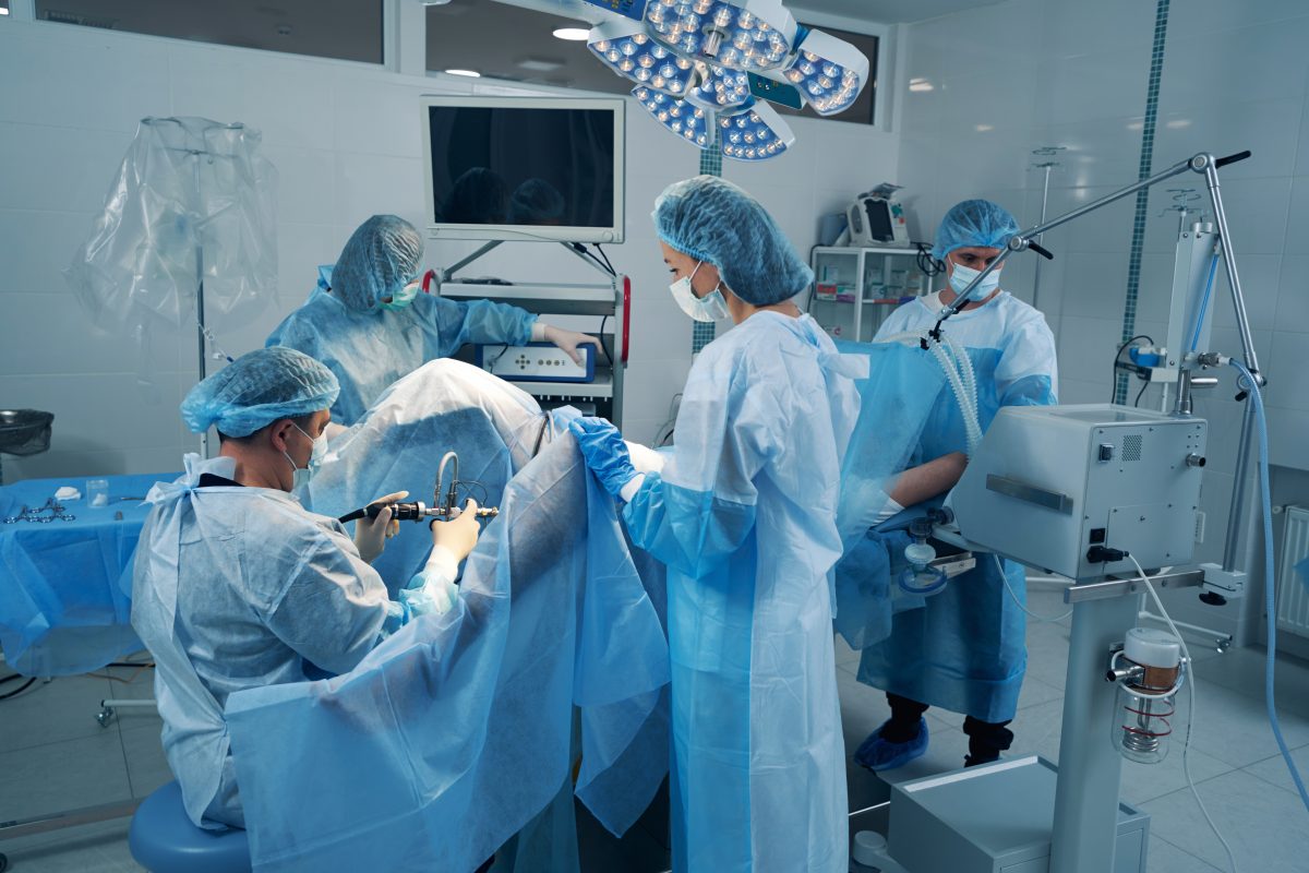 Four surgery specialist in operating theater treating patient