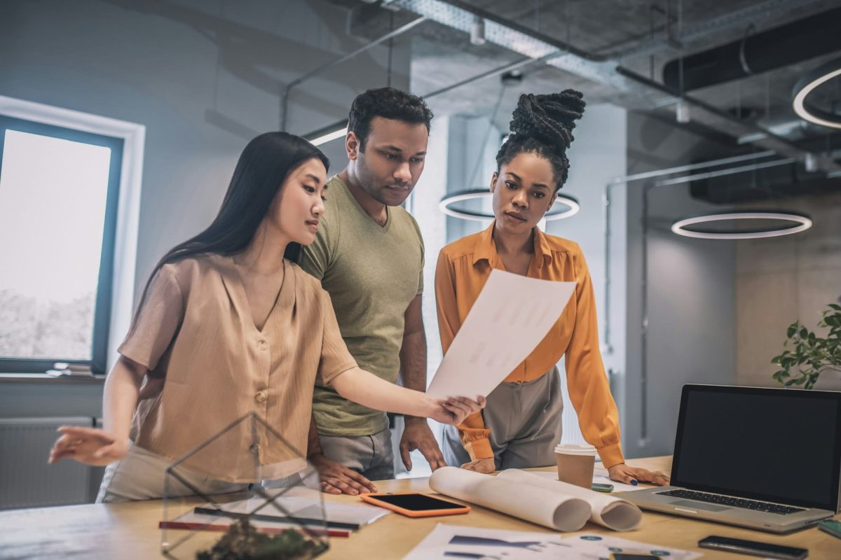 Guy and two girls looking at paper document