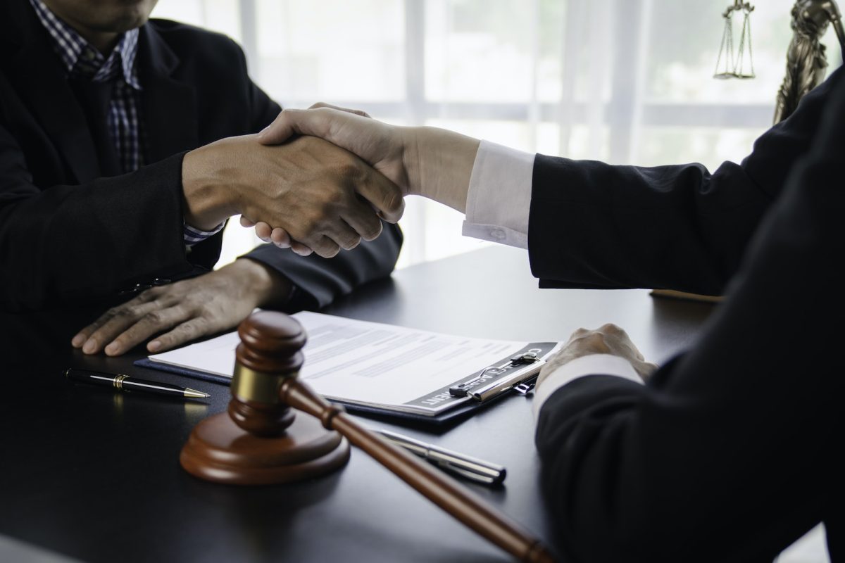 Lawyers shake hands with business people to seal a deal with partner lawyers. or a lawyer discussing