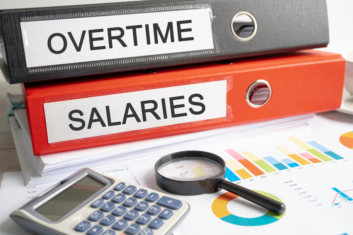 Overtime salaries . Binder data finance report business with graph analysis in office.