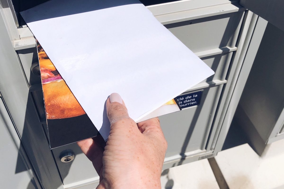 Woman is getting mail from community mailbox